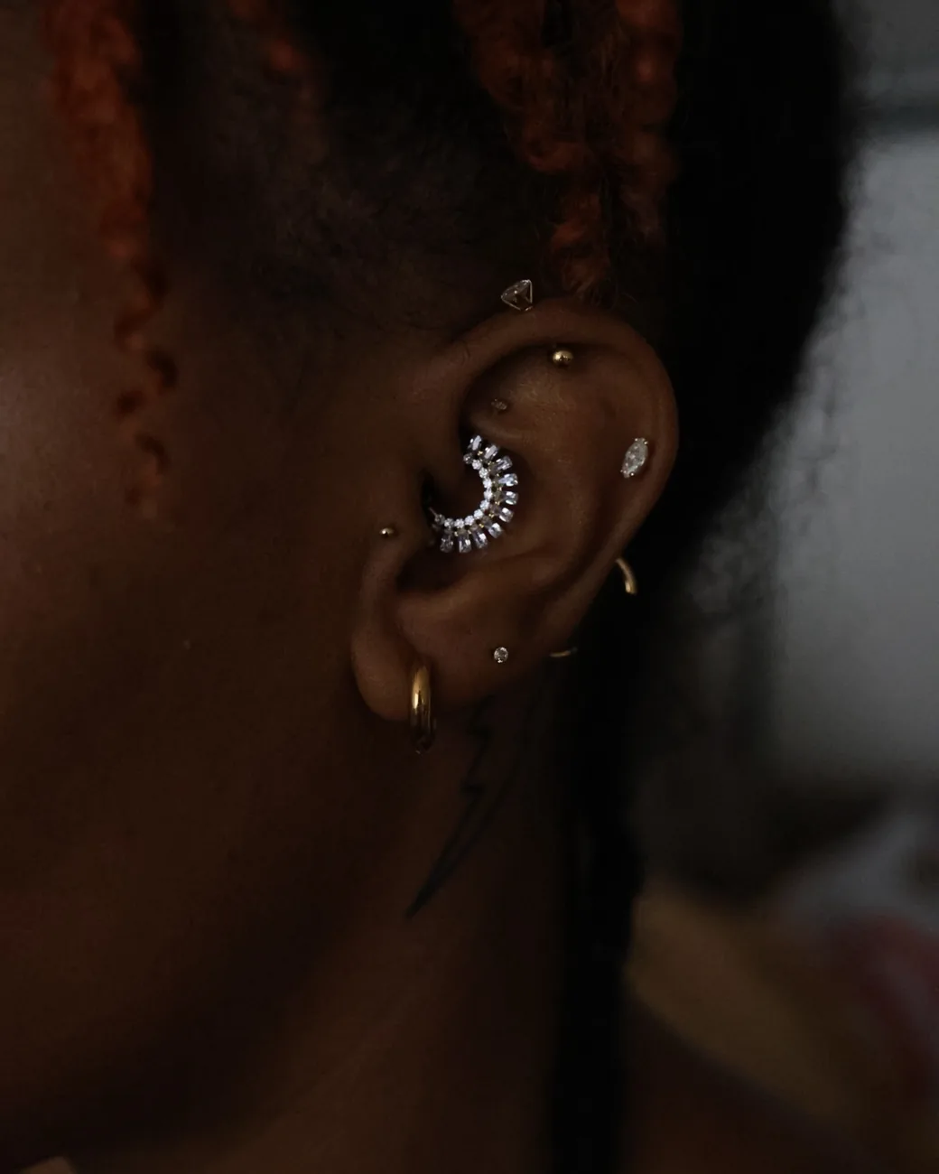 A daith piercing with a decorative gold cluster ring.