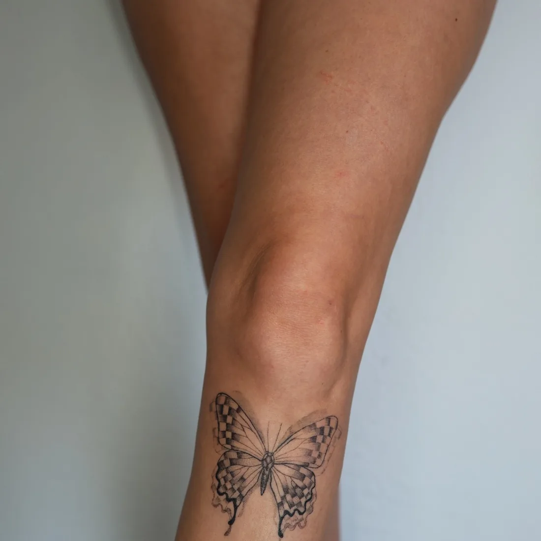 A fine line butterfly on a forearm.